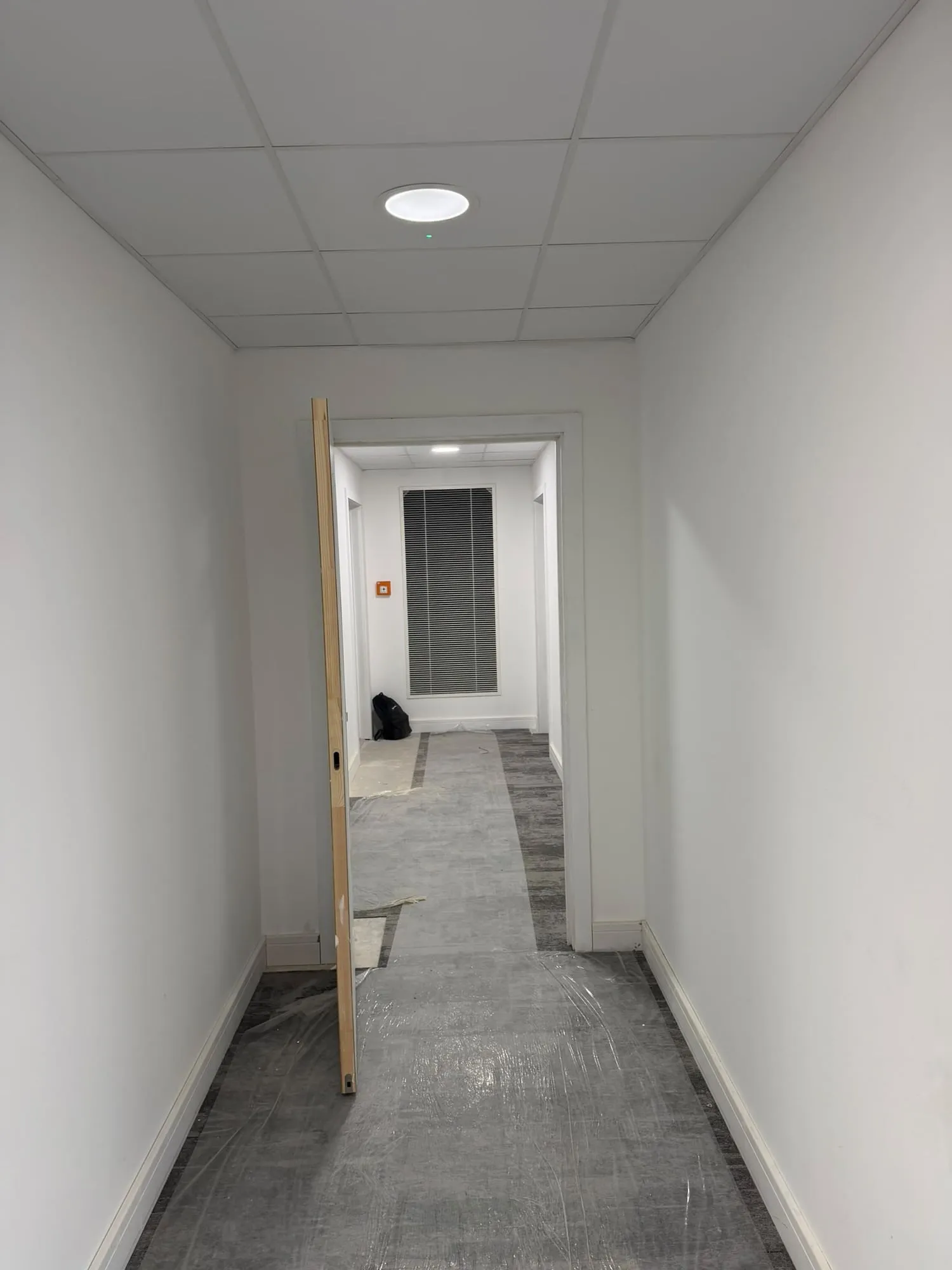 Finished corridor with jointed walls under a suspended ceiling