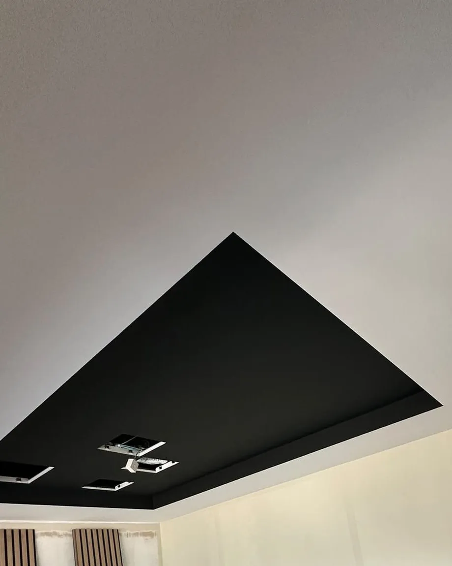 Finished room with a dark recessed ceiling bulkhead and smooth jointed walls