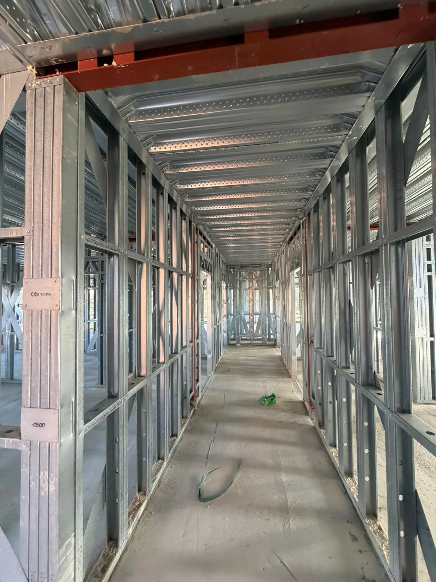 Metal stud partitions set out along both sides of a corridor before boarding